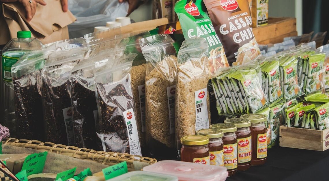 An assortment of packaged foods displayed on a market stall indoors, showcasing variety.